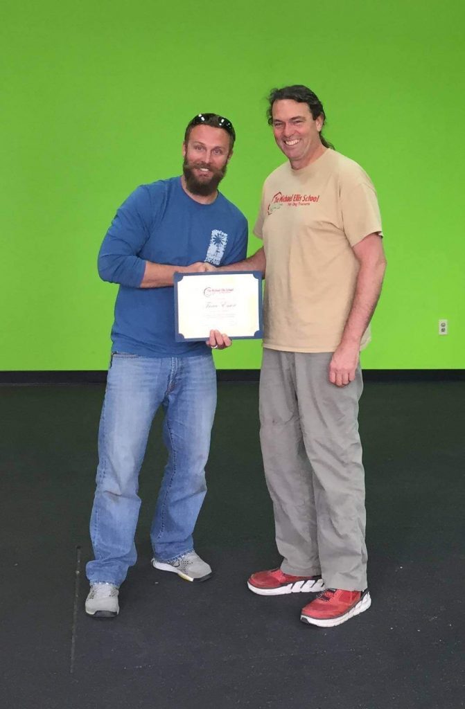 Two men standing next to each other holding a certificate.